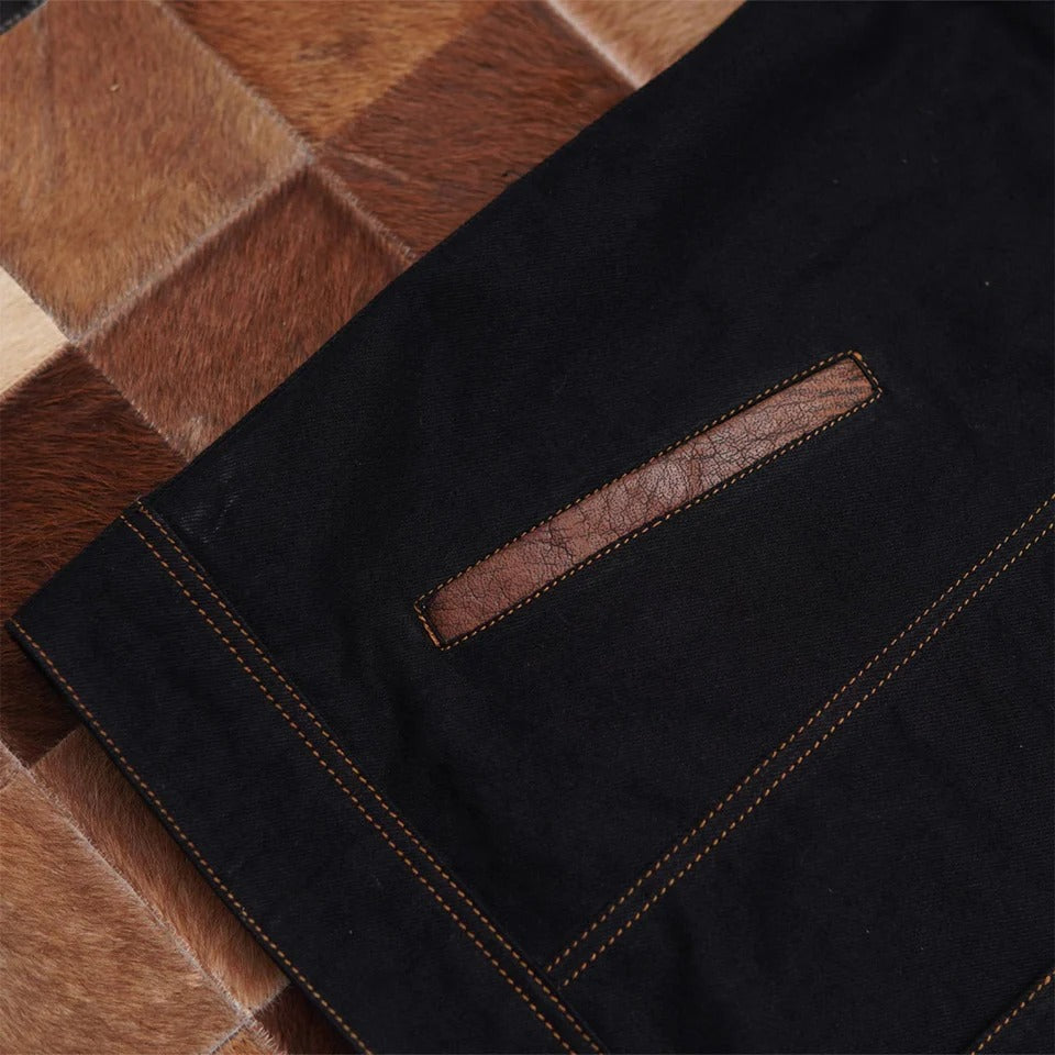 Close-up of dark denim fabric with a leather patch