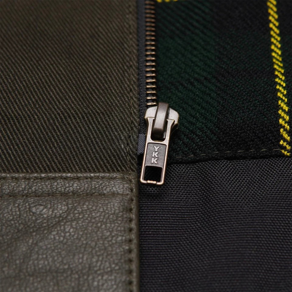 Close-up of a zipper on a textured fabric surface with 'YKK' branding.
