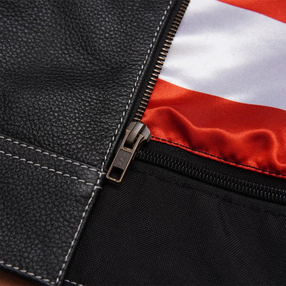 Close-up of a black leather jacket with a zipper, showing a red 