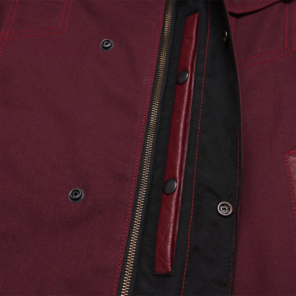 Close-up of a maroon jacket with a zipper and leather pull tab.